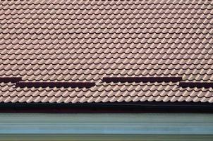 een fragment van een dak van een metaal tegel van donker rood kleur. kwaliteit dakbedekking foto