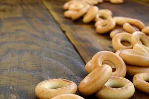 een veel van vers geel bagels liggen Aan de oppervlakte van de oud donker hout. een populair soort van meel producten. een van de traditioneel Russisch behandelt voor thee foto