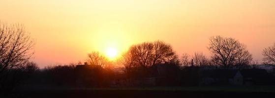 dageraad in de dorp. zonsopkomst in de buitenwijk landschap foto