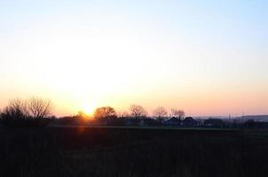 dageraad in de dorp. zonsopkomst in de buitenwijk landschap foto