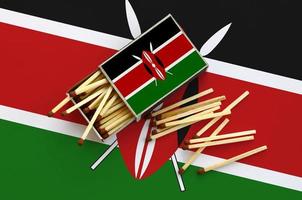 Kenia vlag is getoond Aan een Open luciferdoosje, van welke meerdere wedstrijden vallen en leugens Aan een groot vlag foto