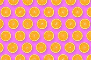 patroon van een oranje citrus plakjes Aan helder Purper achtergrond foto