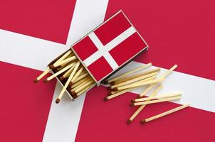 Denemarken vlag is getoond Aan een Open luciferdoosje, van welke meerdere wedstrijden vallen en leugens Aan een groot vlag foto