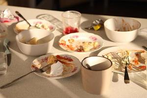 leeg vuil borden met lepels en vorken Aan de tafel na maaltijd. banket einde concept. ongewassen gerechten foto