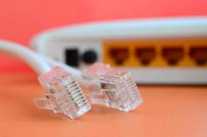 internet router en internet kabel pluggen liggen Aan een helder oranje achtergrond. items verplicht voor internet verbinding foto