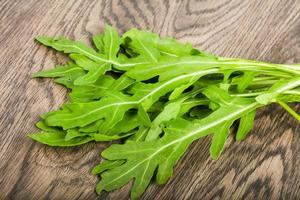 rucola bladeren Aan houten achtergrond foto