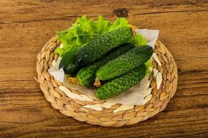 groen komkommers Aan houten bord en houten achtergrond foto