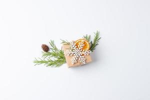 Kerstmis samenstelling met eco vriendelijk geschenk in ambacht papier met rozemarijn Aan wit achtergrond. nul verspilling Kerstmis vakantie concept. vlak leggen, kopiëren ruimte foto