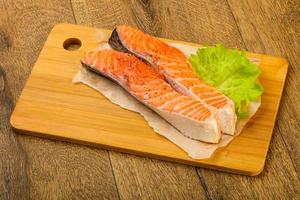 rauw Zalm Aan houten bord en houten achtergrond foto