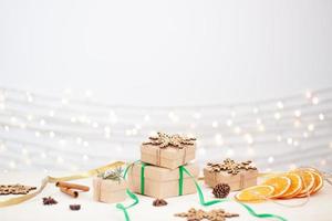 eco vriendelijk verpakking cadeaus in ambacht papier Aan houten tafel. nul verspilling Kerstmis vakantie concept. dichtbij omhoog, kopiëren ruimte. foto