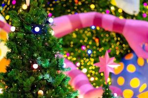 klein Kerstmis boom met kleurrijk bokeh lichten achtergrond van een ander groot een voor Kerstmis vakantie festival. foto