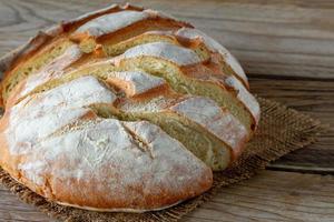 vers gebakken brood Aan houten grijs keuken tafel, eigengemaakt gebakje. foto