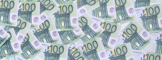 achtergrond patroon van een reeks van groen monetair denominaties van 100 euro. een veel van geld vormen een eindeloos hoop foto