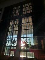 een venster met een latwerk dat schijnt in de ochtend- zon foto