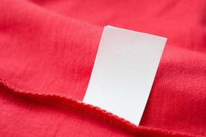 wit wasserij zorg het wassen instructies kleren etiket Aan rood katoen overhemd foto