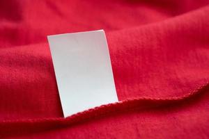 wit wasserij zorg het wassen instructies kleren etiket Aan rood katoen overhemd foto