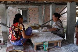 ogan ilir, Indonesië -oktober 27, 2021, twee Dames werk en pratend naar elk andere maken voedsel traditioneel foto