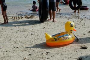 lampoeng, Indonesië - mei 15, 2022, geel eend zwemmen band voor kinderen gewassen omhoog Aan de strand foto