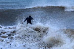 surfing Aan hoog golven Aan de middellandse Zee zee in noordelijk Israël. foto