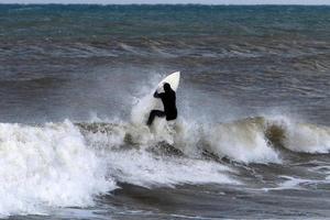 surfing Aan hoog golven Aan de middellandse Zee zee in noordelijk Israël. foto