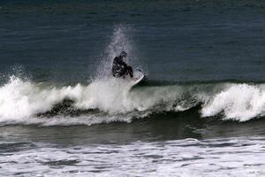 surfing Aan hoog golven Aan de middellandse Zee zee in noordelijk Israël. foto