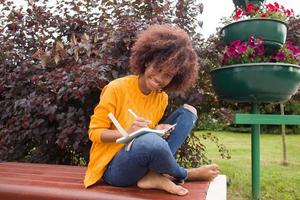 een gelukkige en jonge Afro-Amerikaanse student in het park foto