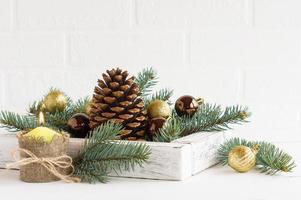 Kerstmis samenstelling voor de decoratie van de nieuw jaar tafel en huis. kaars gemaakt met uw eigen handen, een doos met helder speelgoed en een ceder ijshoorntje. foto