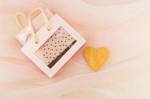 geschenk doos in een mooi roze zak Aan een pastel achtergrond sluier met een hart van goud. een geschenk met liefde. foto