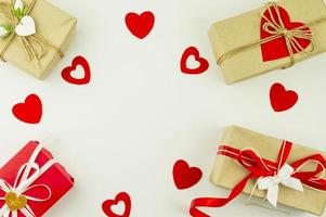Valentijnsdag dag vakantie achtergrond. geschenk dozen in ambacht papier, versierd met gekleurde harten en rood harten Aan een wit achtergrond. top visie. vlak leggen.