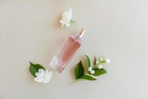 top visie van een glas fles van vrouwen parfum of toilet water met bloemknoppen en bloemen van geurig jasmijn. een kopiëren van de ruimte. een sjabloon voor de visie. foto