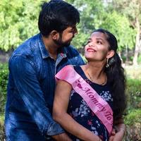 indiase paar poseren voor zwangerschaps baby shoot. het paar poseert in een gazon met groen gras en de vrouw pronkt met haar babybuil in de Lodhi-tuin in New Delhi, India foto