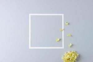 kunstmatig achtergrond met bloemen en wit kader Aan grijs. vlak leggen, kopiëren ruimte foto
