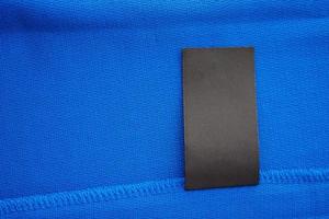 zwart blanco wasserij zorg kleren etiket Aan blauw Jersey polyester sport overhemd achtergrond foto