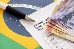 pen met braziliaans geld rekeningen Aan blanco van loterij spel. concept van geluk en het gokken in Brazilië foto