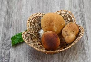 wilde paddestoelen in een mand op houten achtergrond foto