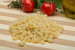 schelp pasta Aan houten bord en houten achtergrond foto