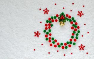 vlak leggen van Kerstmis ornamenten reeks net zo een krans zetten Aan sneeuw achtergrond. foto