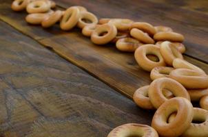 een veel van vers geel bagels liggen Aan de oppervlakte van de oud donker hout. een populair soort van meel producten. een van de traditioneel Russisch behandelt voor thee foto