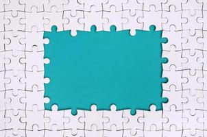 framing in de het formulier van een rechthoek, gemaakt van een wit decoupeerzaag puzzel in de omgeving van de blauw ruimte foto