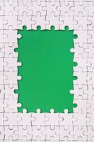 framing in de het formulier van een rechthoek, gemaakt van een wit decoupeerzaag puzzel in de omgeving van de groen ruimte foto