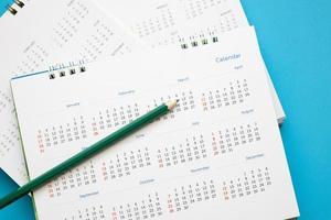 kalender bladzijde met potlood dichtbij omhoog Aan blauw achtergrond bedrijf planning afspraak vergadering concept foto