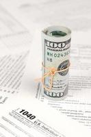1040 individu inkomen belasting terugkeer het formulier met rollen van Amerikaans dollar bankbiljetten foto