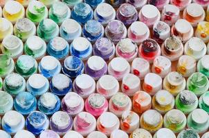 een patroon van een veel mondstukken van een verf sproeier voor tekening graffiti, besmeurd in verschillend kleuren. de plastic petten zijn geregeld in veel rijen vormen de kleur van de regenboog foto