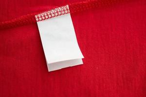 wit wasserij zorg het wassen instructies kleren etiket Aan rood katoen overhemd foto