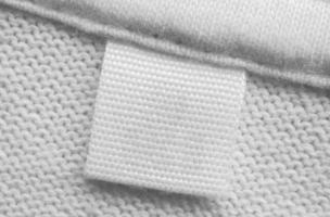 wit blanco wasserij zorg kleren etiket Aan katoen overhemd achtergrond foto