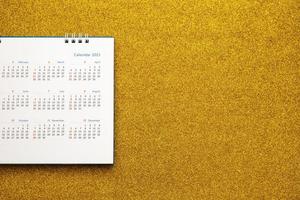gelukkig nieuw jaar 2021 kalender bladzijde dichtbij omhoog Aan goud schitteren fonkeling achtergrond foto