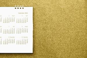 gelukkig nieuw jaar 2021 kalender bladzijde dichtbij omhoog Aan goud schitteren fonkeling achtergrond foto