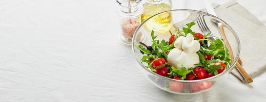 burrata, Italiaans vers kaas gemaakt van room en buffel of koe melk, met tomaat, rucola en rood basilicum salade foto