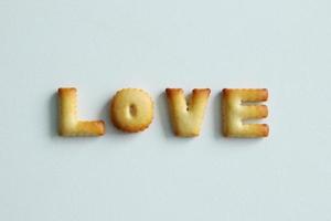 een opschrift van de koekjes Aan de wit achtergrond. tekst - liefde. foto