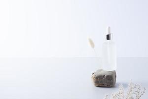 kunstmatig fles met bloemen en steen Aan grijs achtergrond. dichtbij omhoog, kopiëren ruimte foto